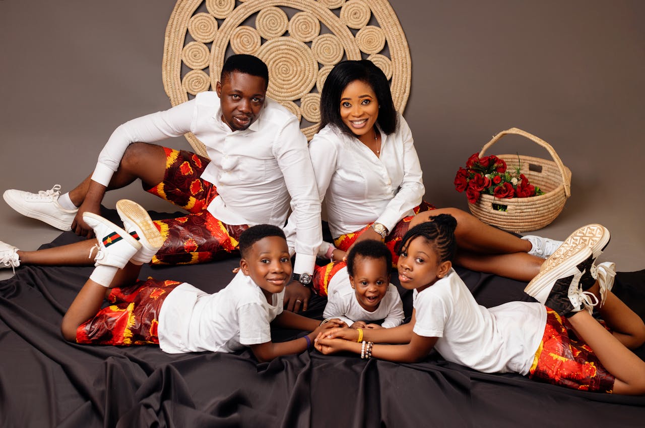 A joyful family of five in matching outfits posing happily together indoors.