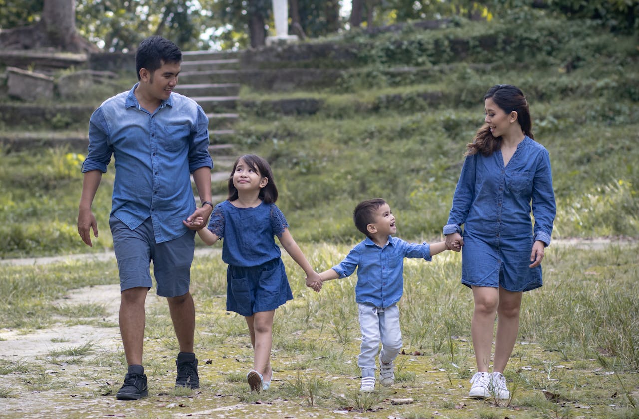 Family enjoying a walk together in a lush outdoor setting, sharing joyful moments.