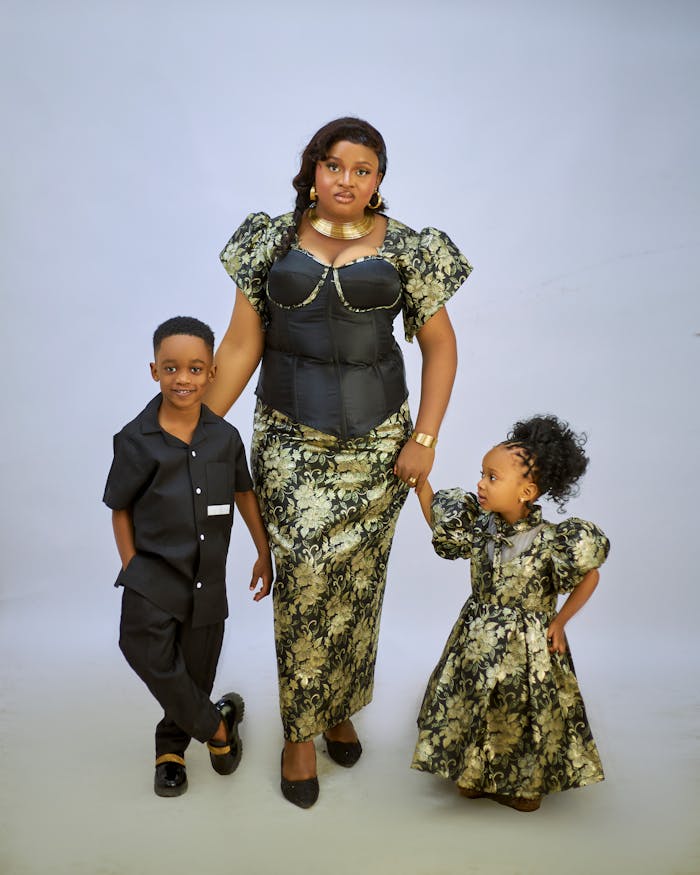 Mother with children in matching African prints, studio portrait.